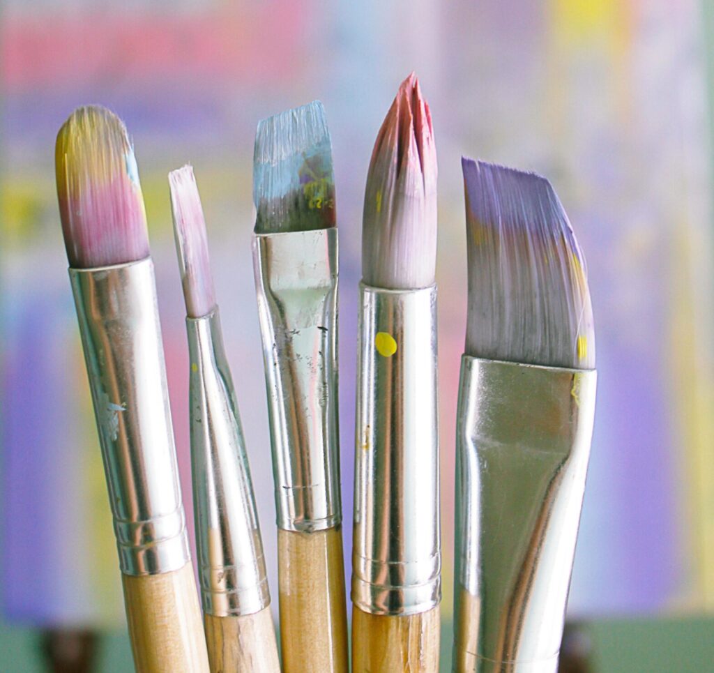 Art brushes with abstract painted canvas in vibrant colors.